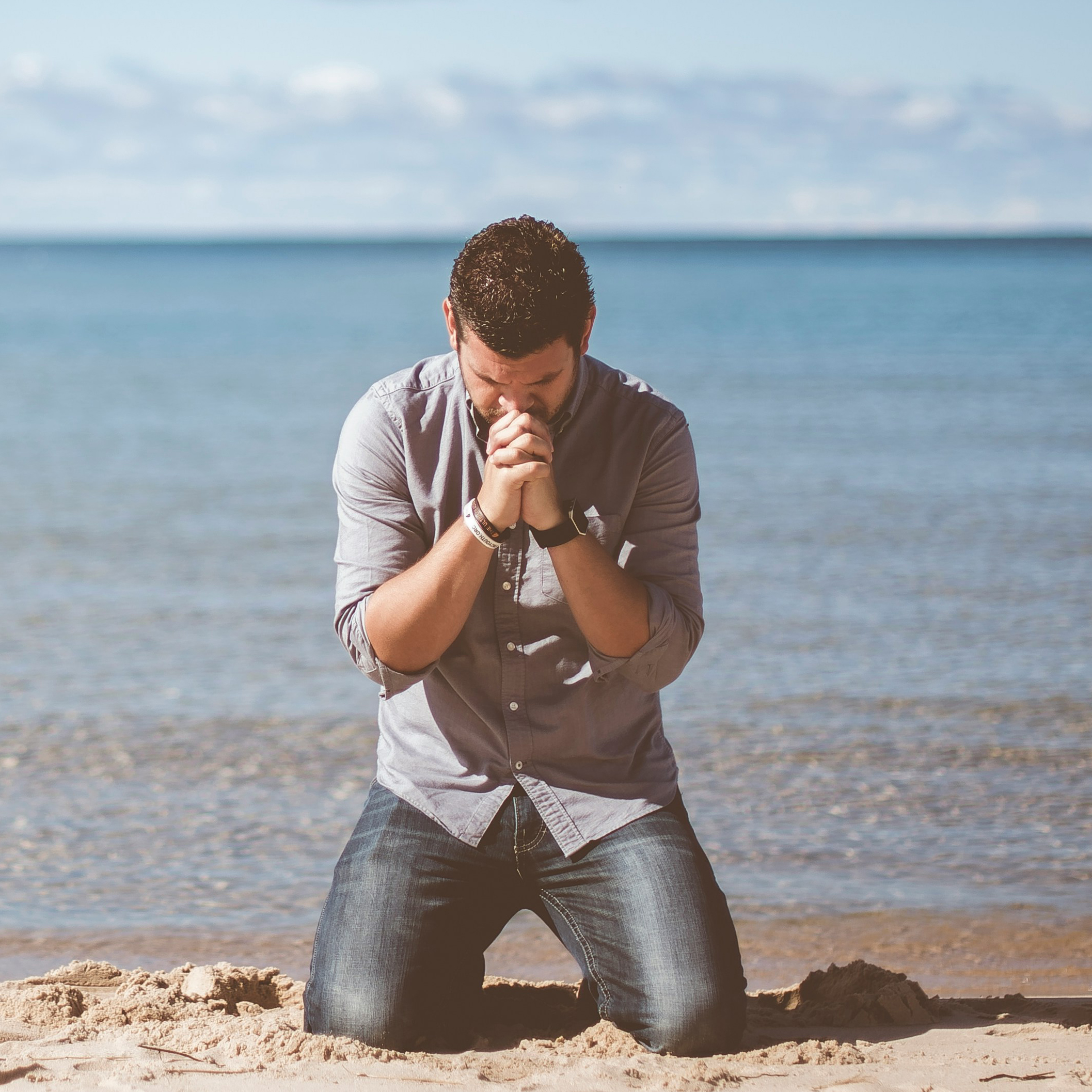 Man Praying on Beach