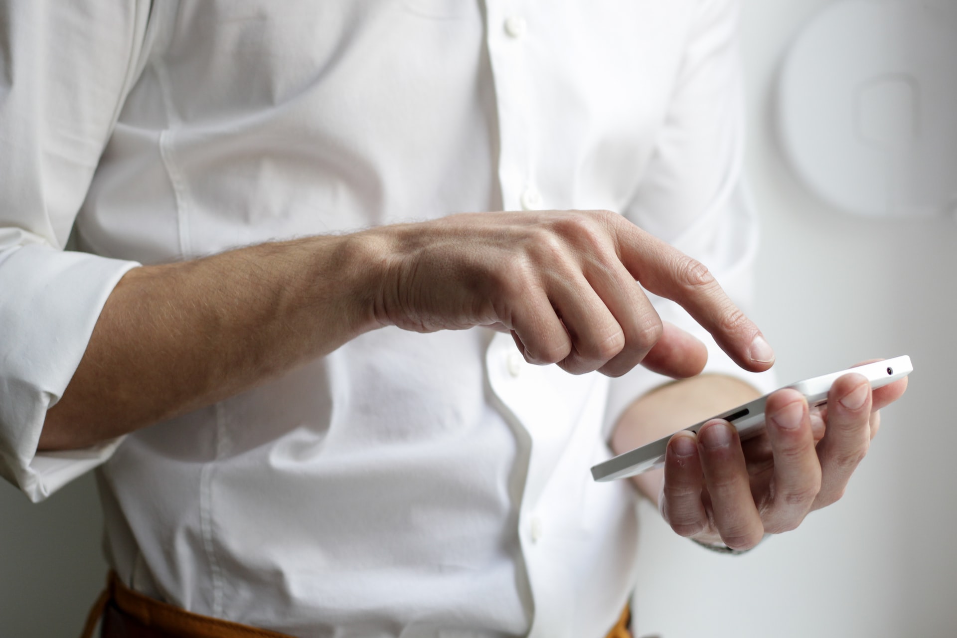 A man dialing a phone number into his mobile phone