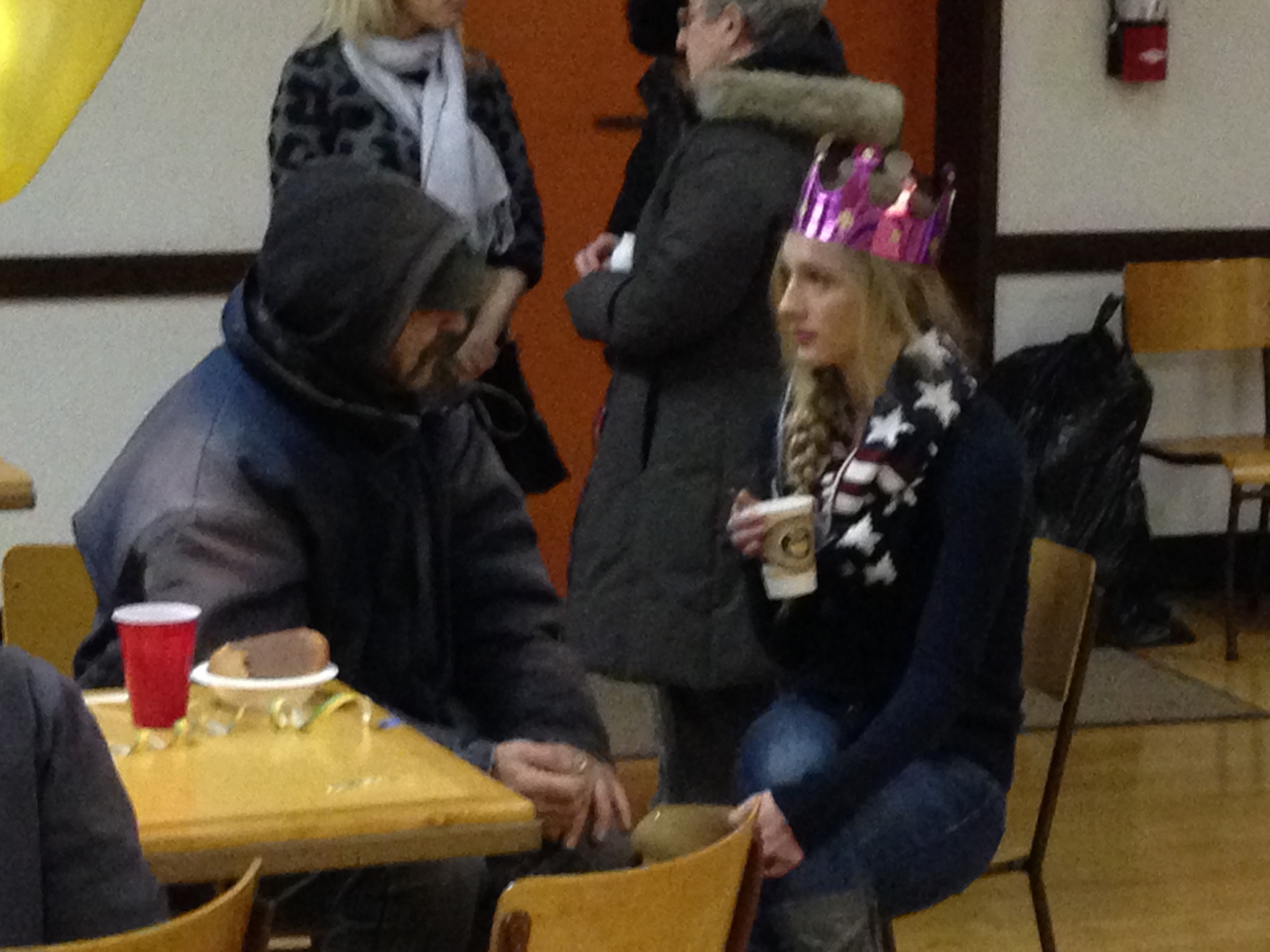 A young woman speaks with an insecure person in a parish hall