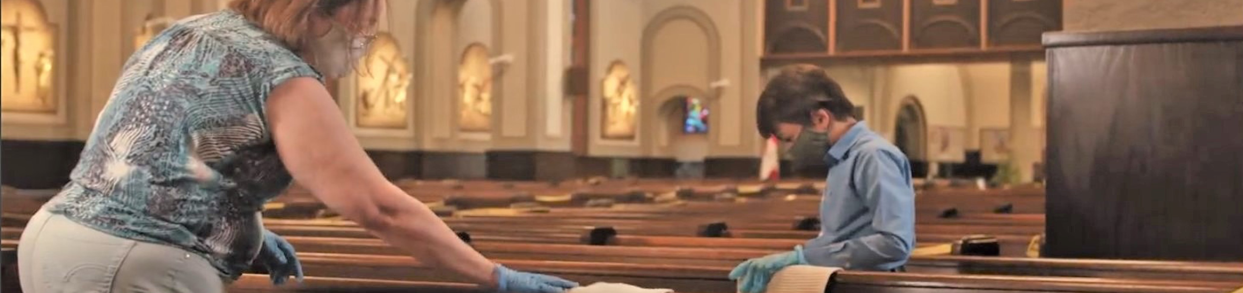 Older woman and young boy cleaning pews in the parish, wearing masks